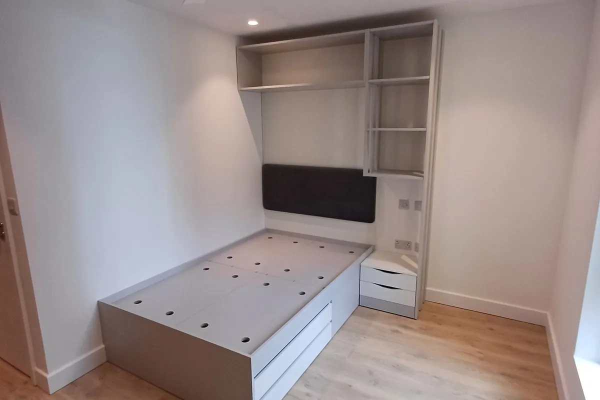 Fitted bed base, wardrobe and overhead shelving in a Lewisham bedroom