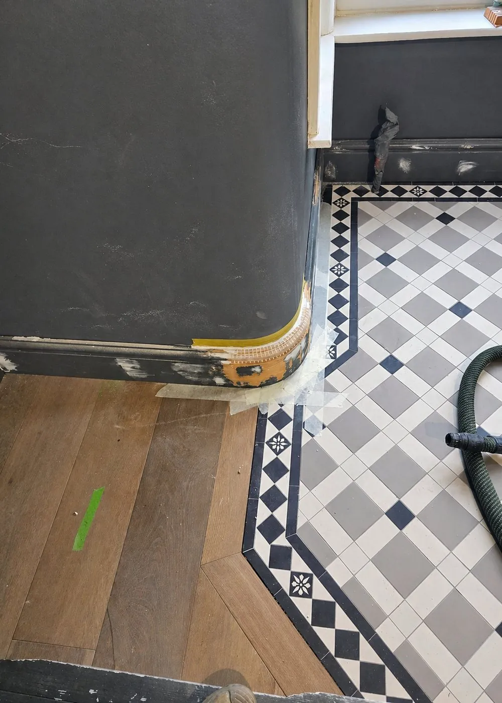 Detail of a curved painted column scribed to a new oak floor and a Victorian tiled border